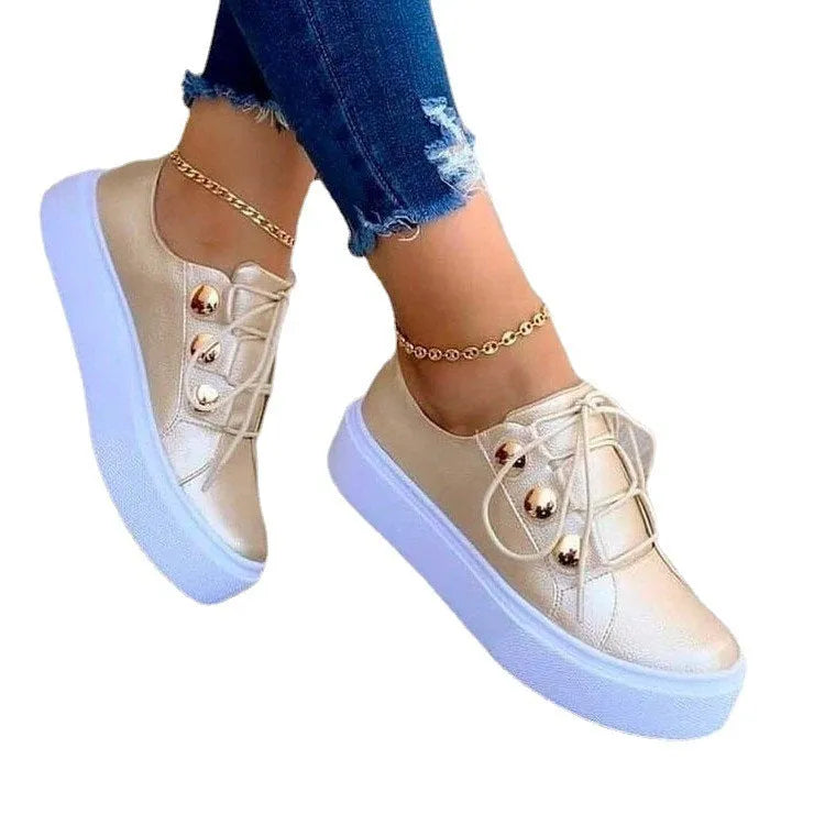 Women's white casual sneakers with decorative rivet details and round toe design