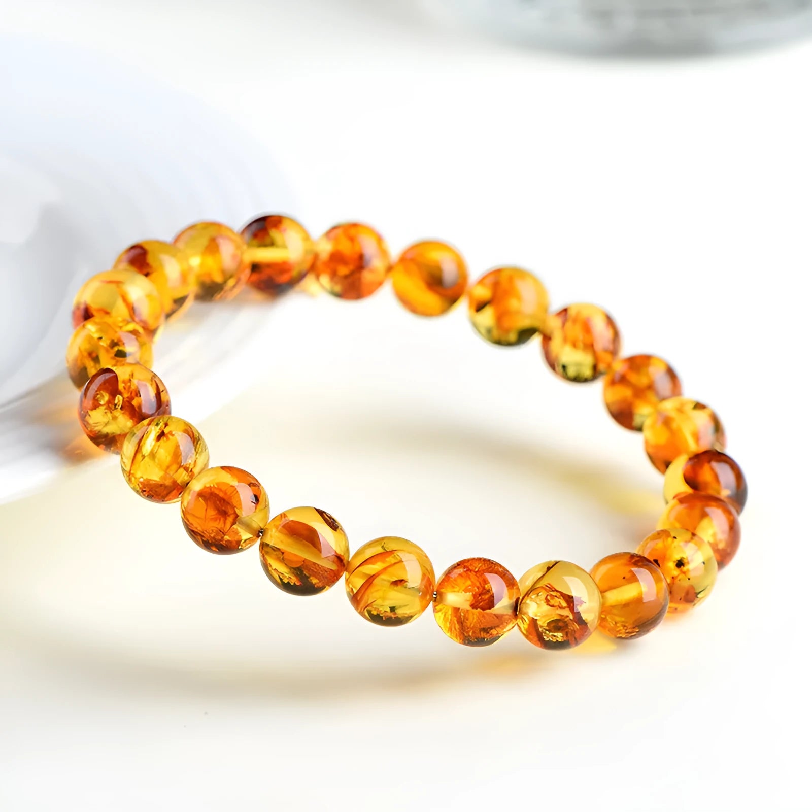Natural yellow piebald amber bracelet with geometric beads on a white background.