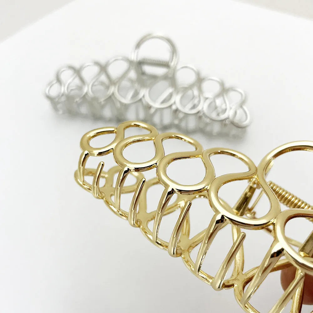 Large gold and silver alloy hair clip with a minimalist design and tassel detail for updo hairstyles.