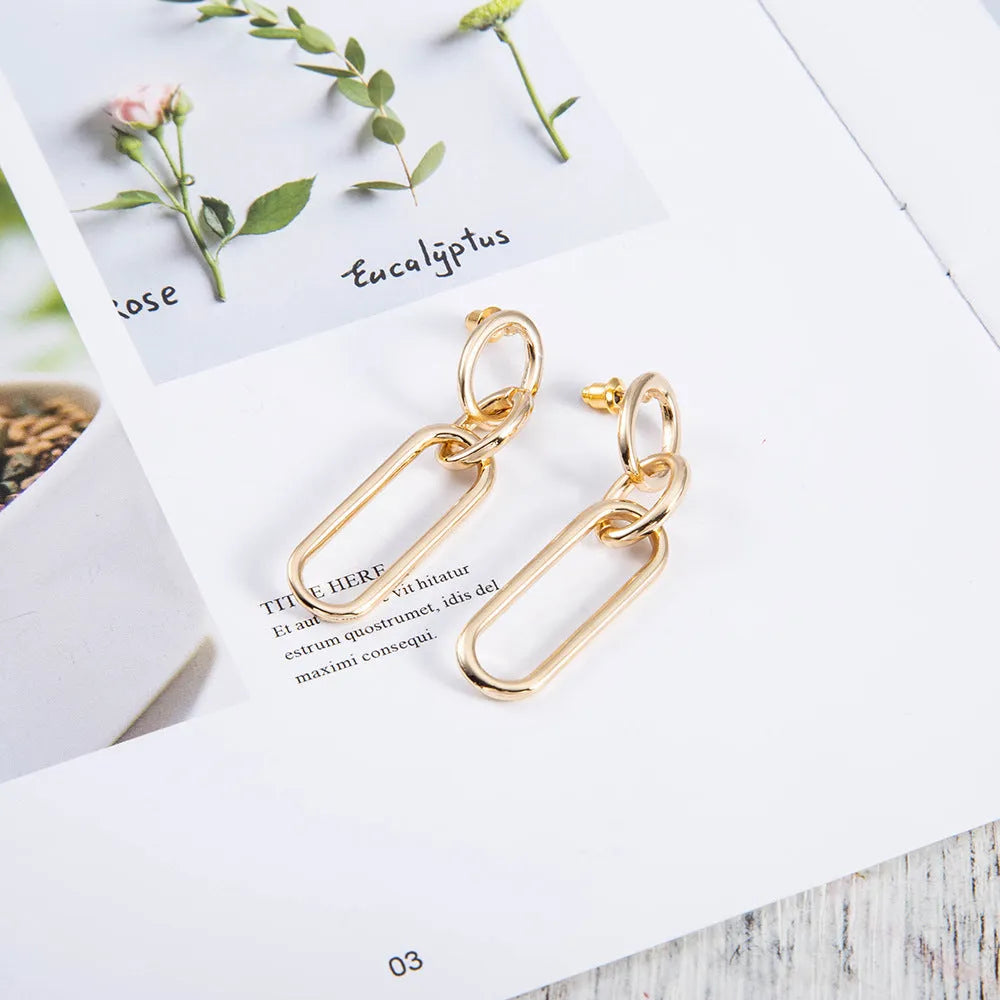 Sterling silver geometric hoop earrings with ring and line design on silver background