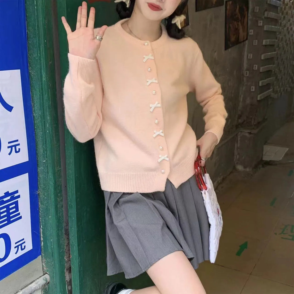 Women's solid colour sweater cardigan with bow detail and pearl buttons