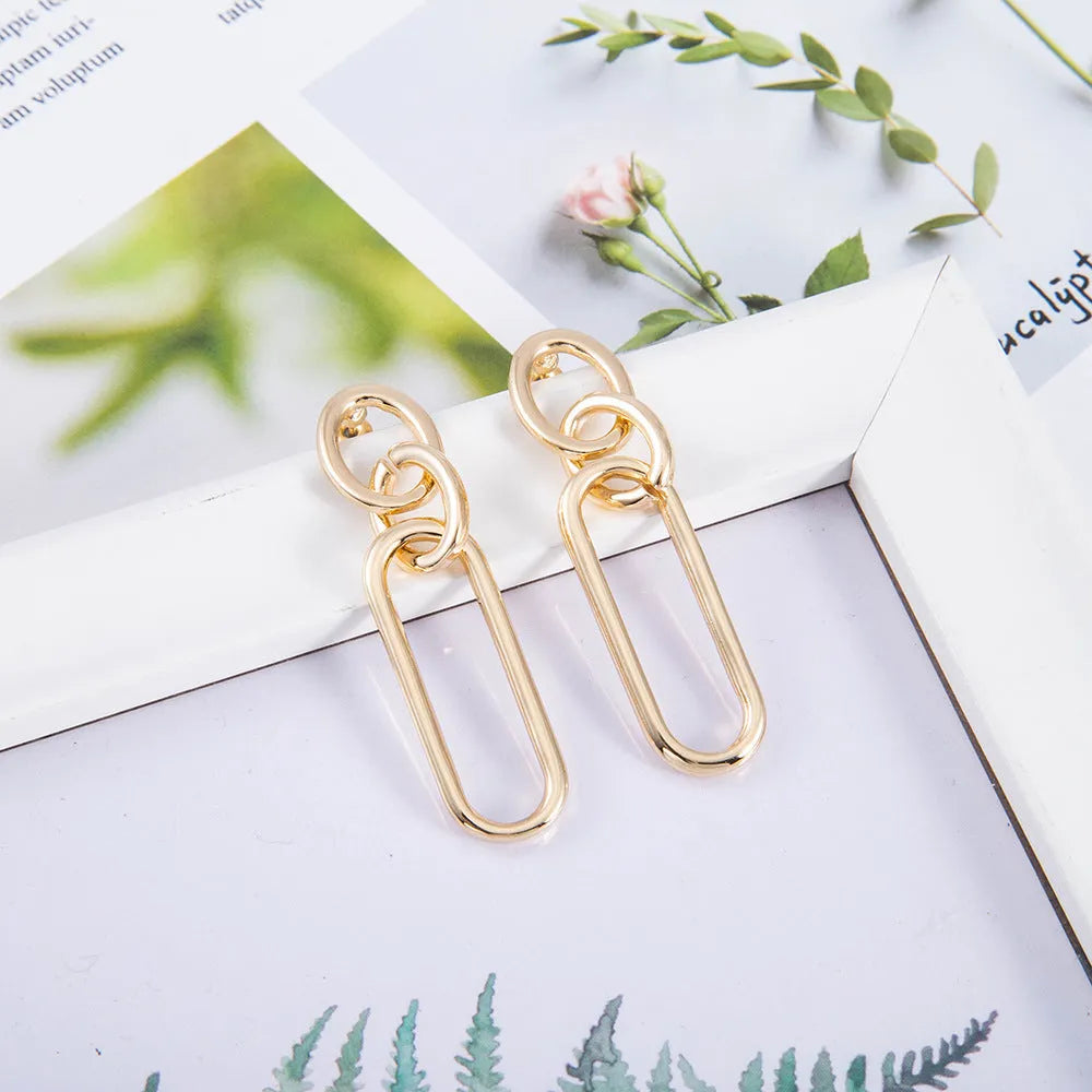 Sterling silver geometric hoop earrings with ring and line design on silver background