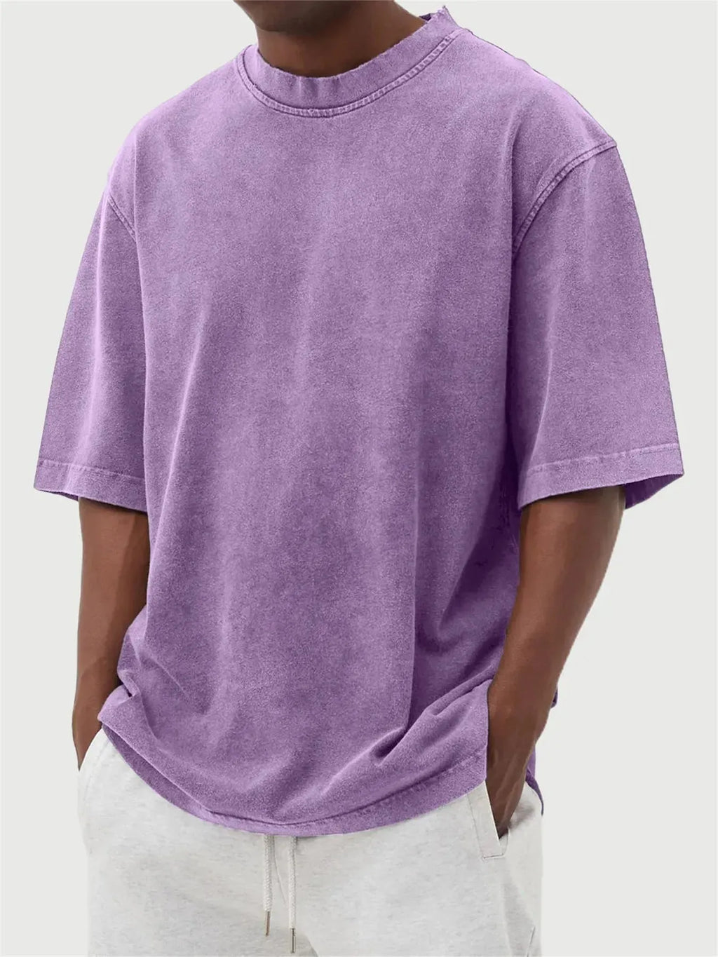 Man wearing a loose-fit distressed pullover T-shirt in a solid colour, showcasing the casual style and half-sleeve design.