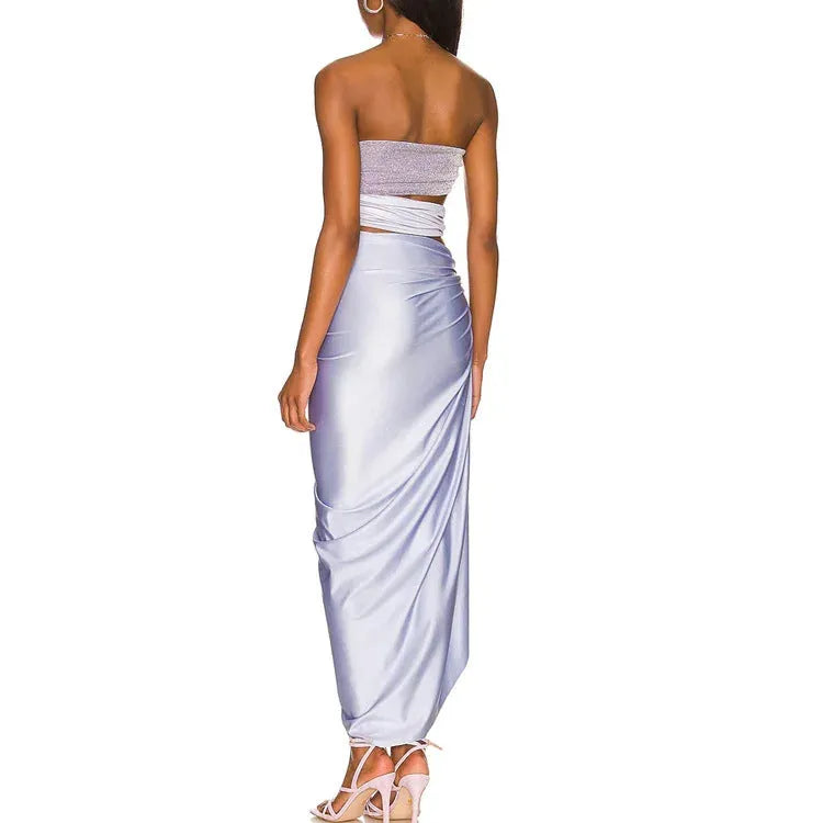 Purple one-piece swimsuit with hollow back and matching wrap skirt laid flat.