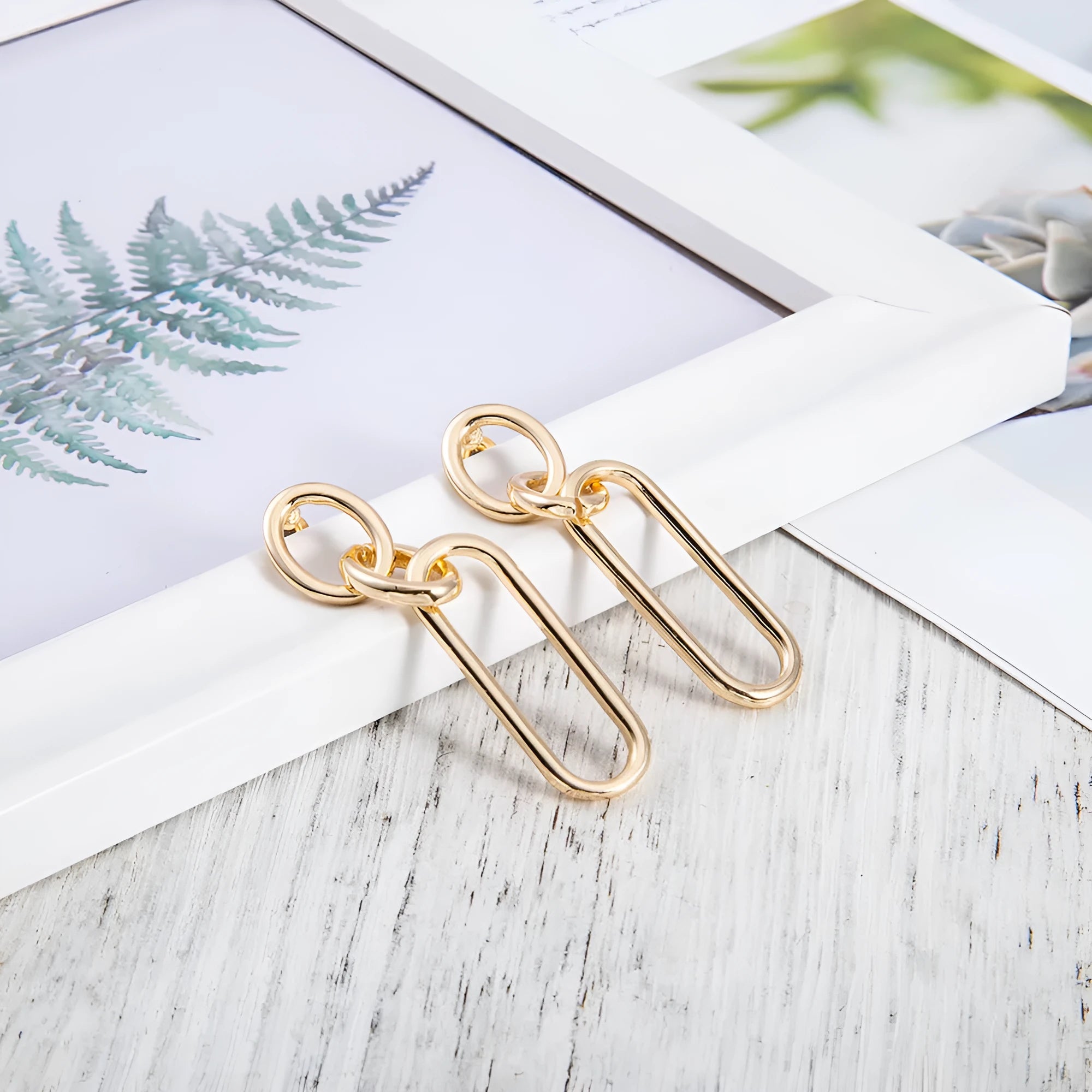 Sterling silver geometric hoop earrings with ring and line design on silver background