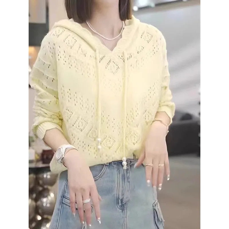 Woman wearing a blue crochet-knit hooded long sleeve pullover top with a loose fit.