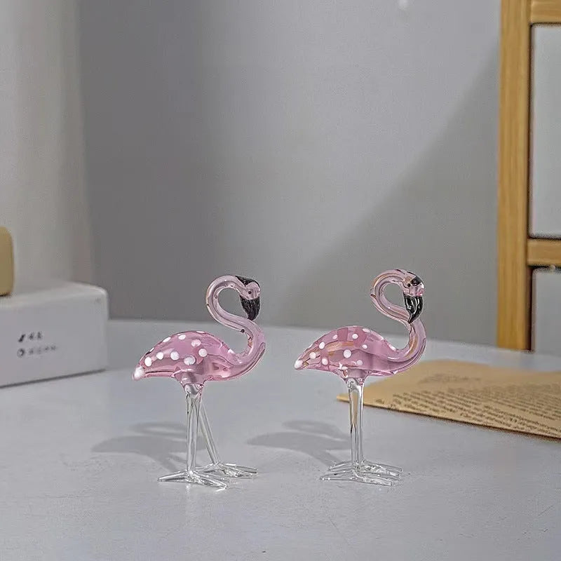 Clear crystal flamingo decorative sculpture with pink dots on a table.