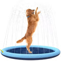Inflatable blue dog sprinkler pool mat with anti-slip texture, connected to a garden hose in a garden.
