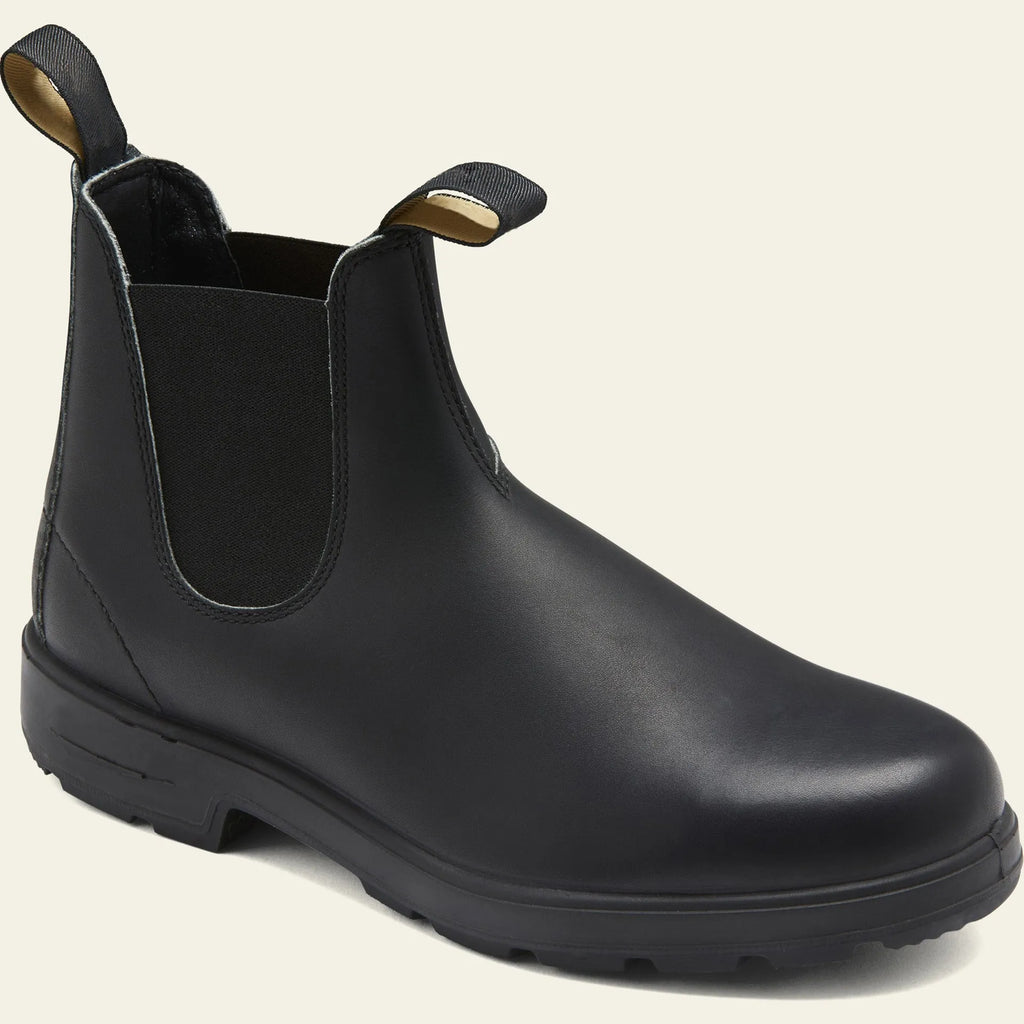 Vintage brown frosted finish Chelsea boots with car suture detailing on a wooden floor.