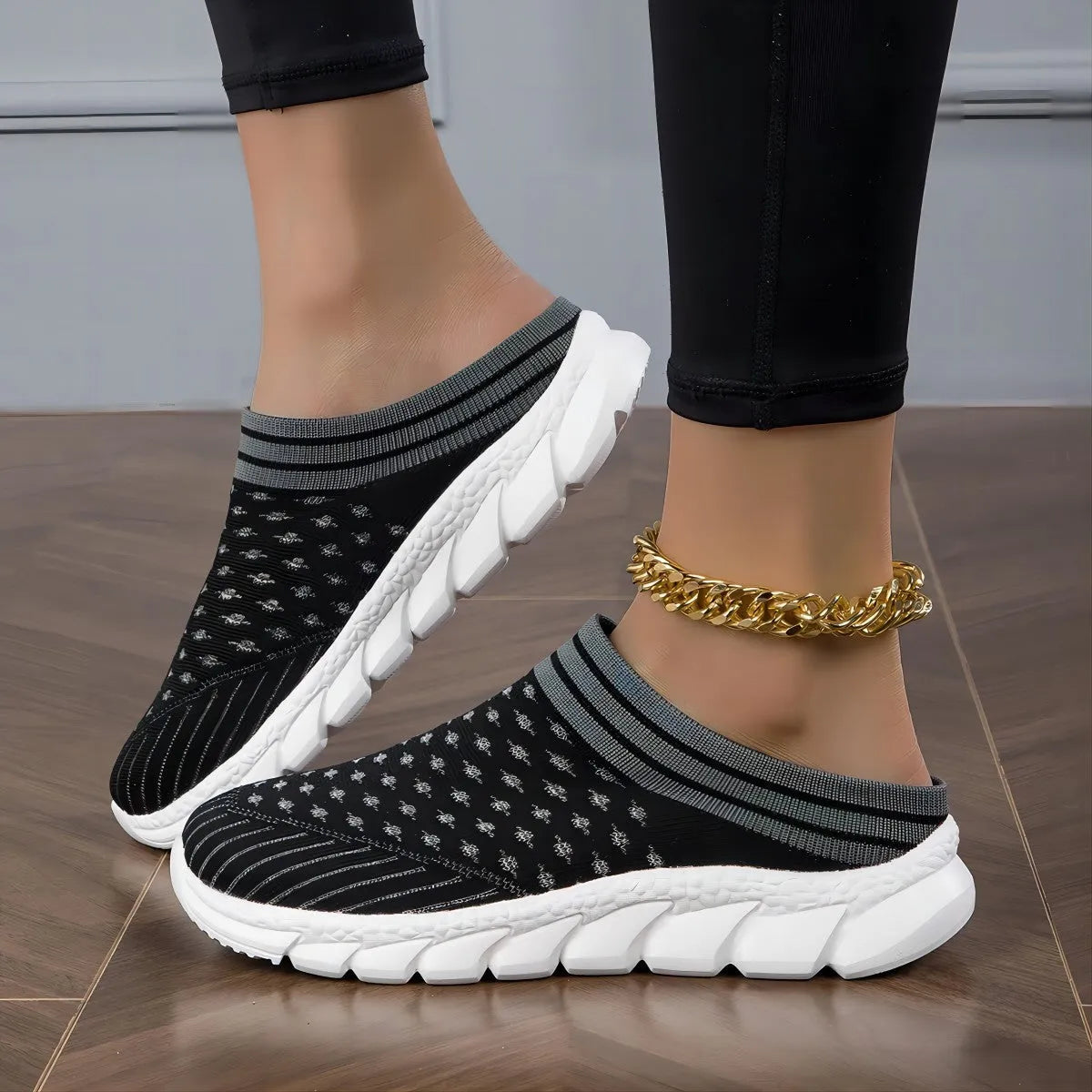 Women's black Flyknit socks semi slipper shoes with striped pattern and hollow-out design on a viscose sole.