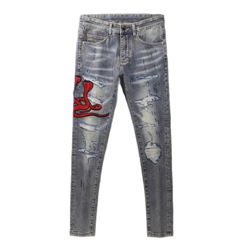 Distressed slim fit jeans with embroidered patches and washed-out vintage colour