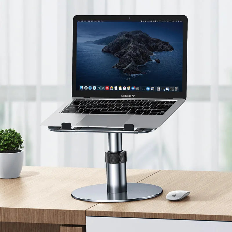 Silver adjustable aluminium laptop stand with rotating base on a desk.