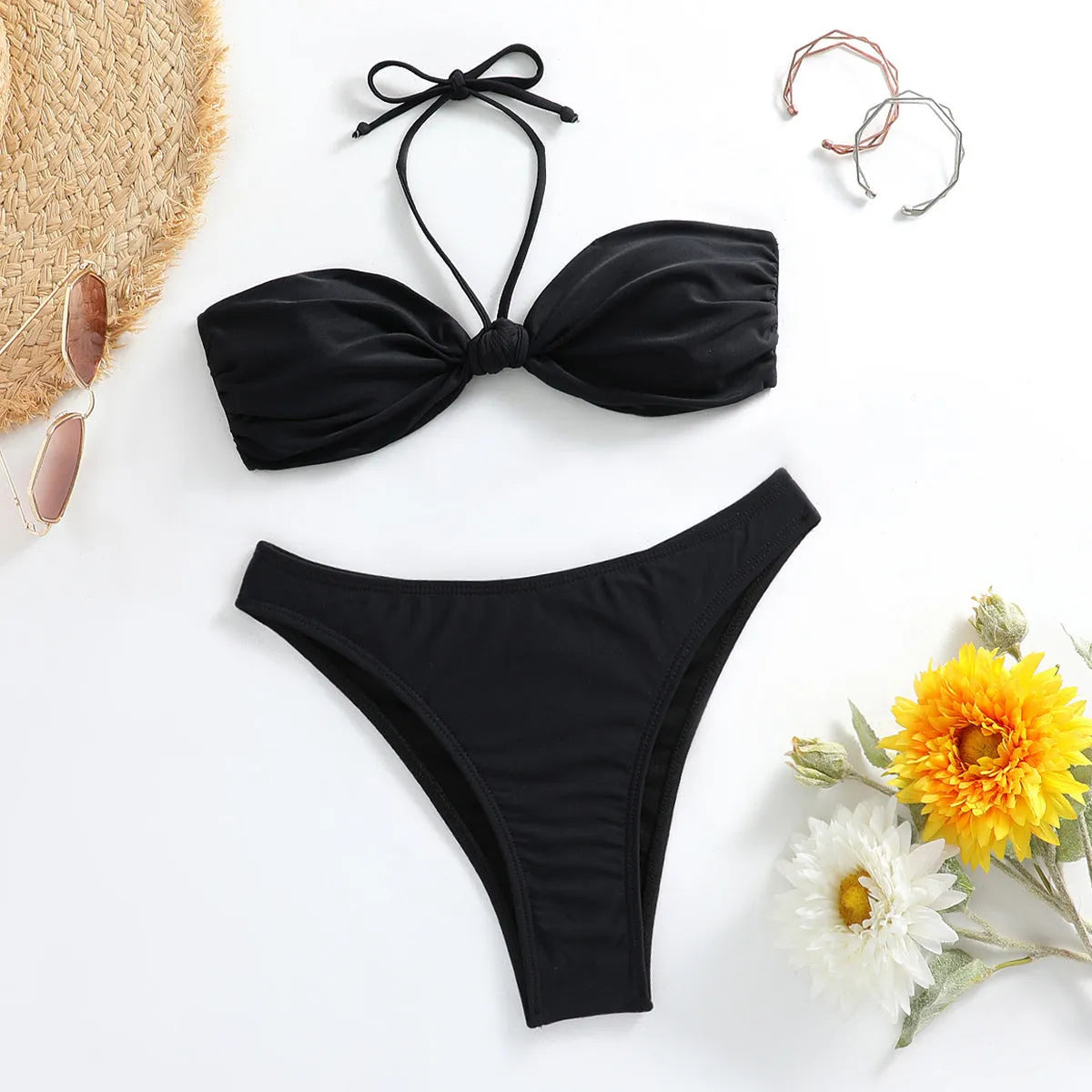 Black women's bikini set with lace-up tube top and briefs on a neutral background.
