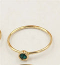 14K gilded gold filled zircon ring on a finger, showing green colour and zircon stones.