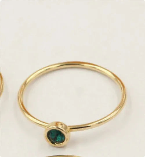 14K gilded gold filled zircon ring on a finger, showing green colour and zircon stones.