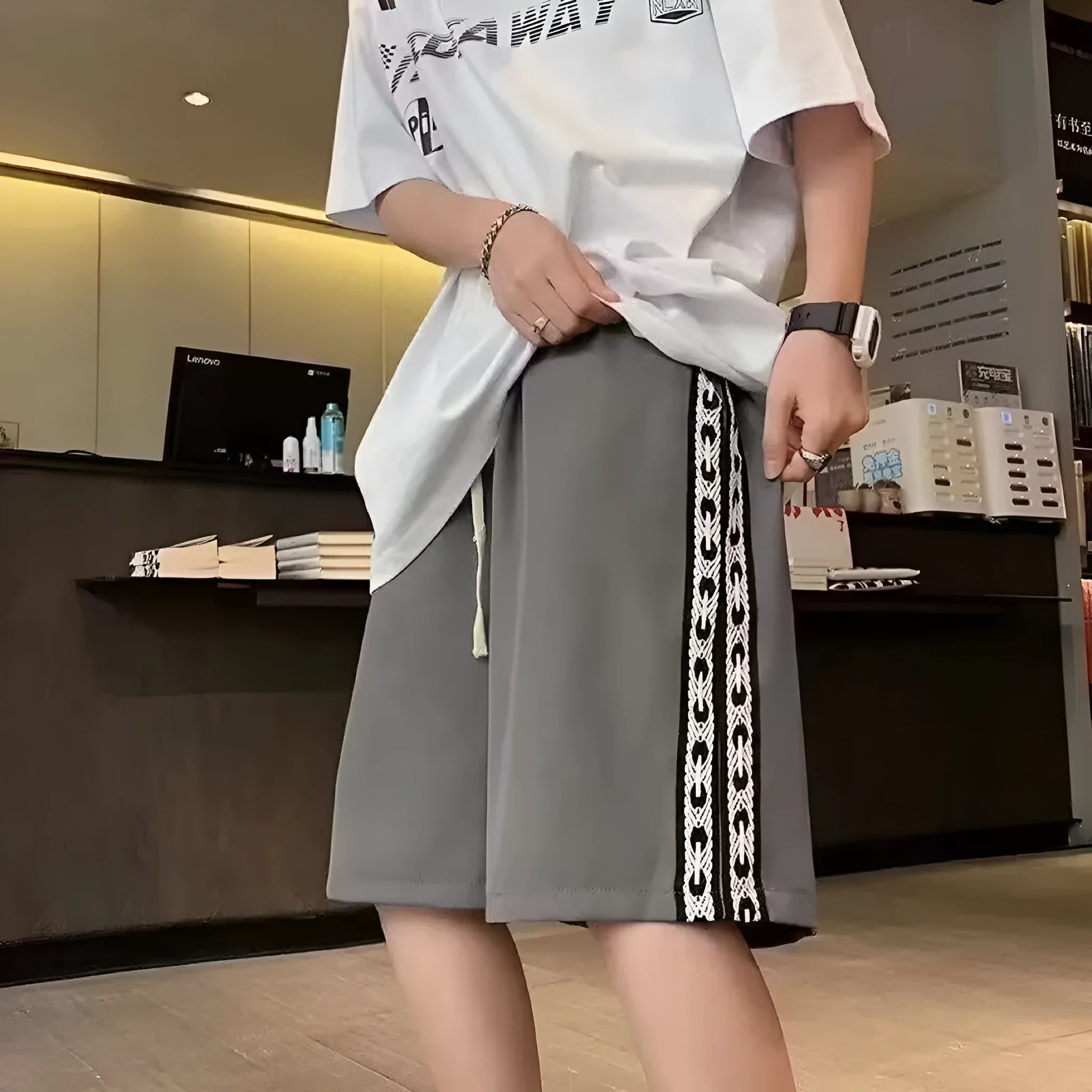 Man wearing loose-fit black track pants made from polyester with a micro-elastic fabric.