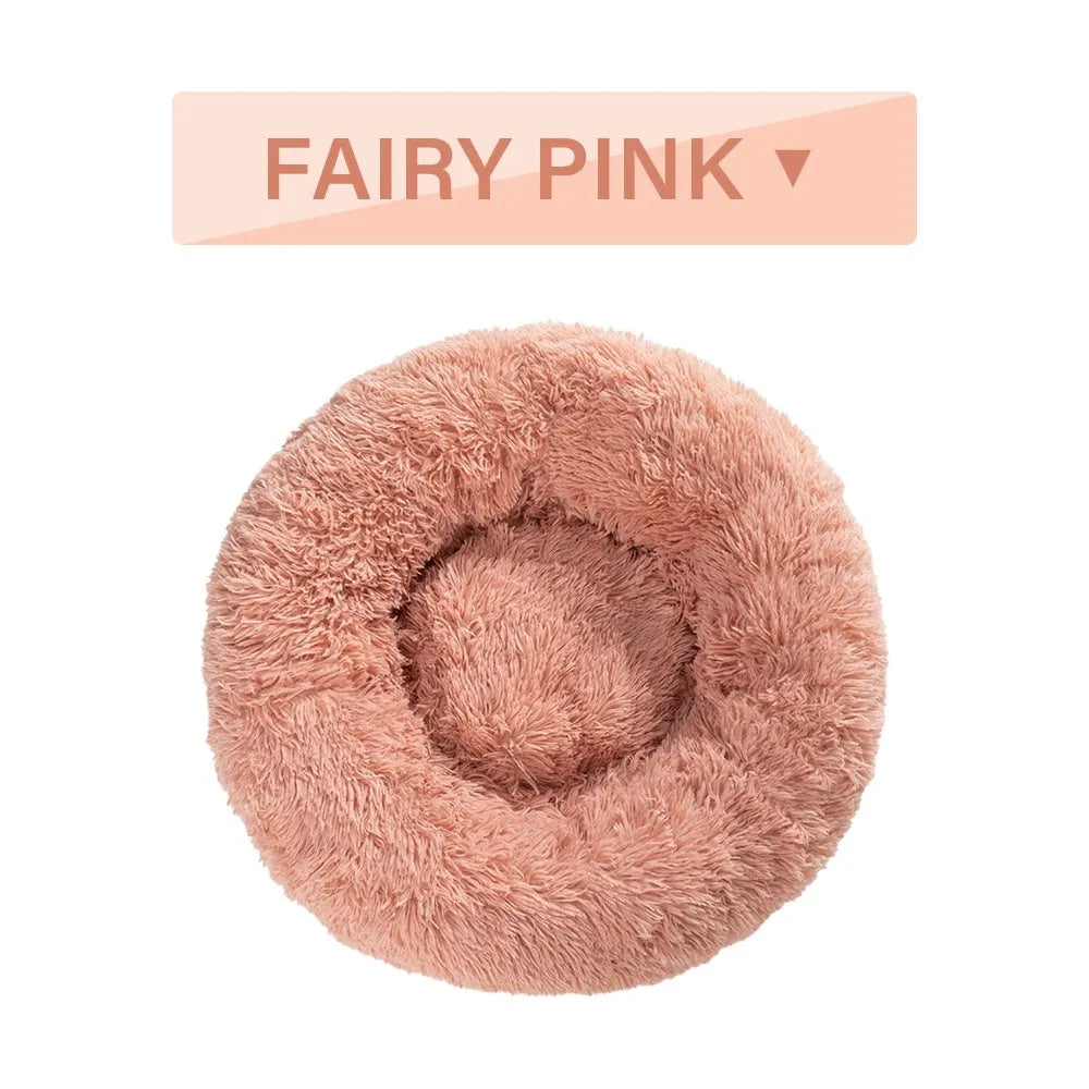 Fluffy grey donut dog bed with raised rim, shown with a small dog sleeping inside.