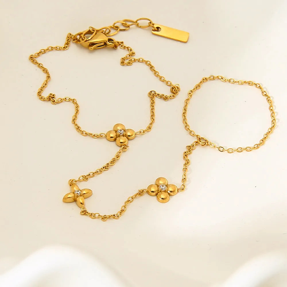 Gold tone women's bracelet with geometric floral and eight-pointed star design in stainless steel