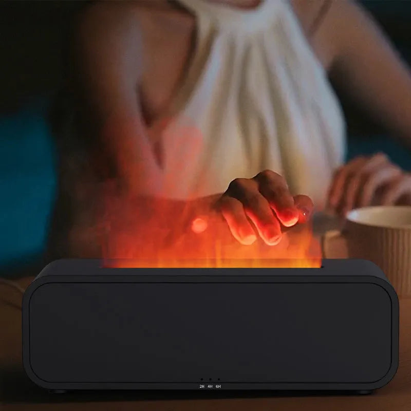 Black and white aroma diffuser with flame animation and coloured LED lights on a wooden table.