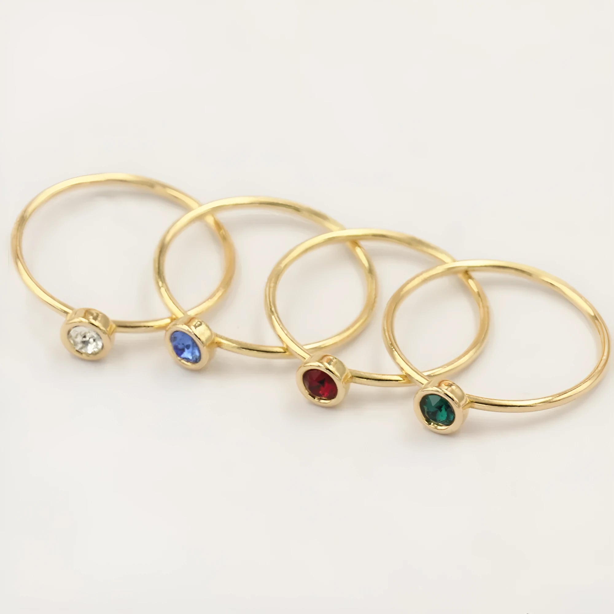 14K gilded gold filled zircon ring on a finger, showing green colour and zircon stones.