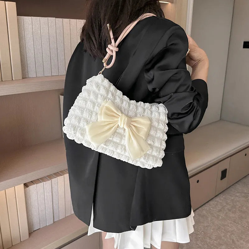 Women's black canvas handbag with single shoulder strap showing horizontal square shape and sandwich pocket