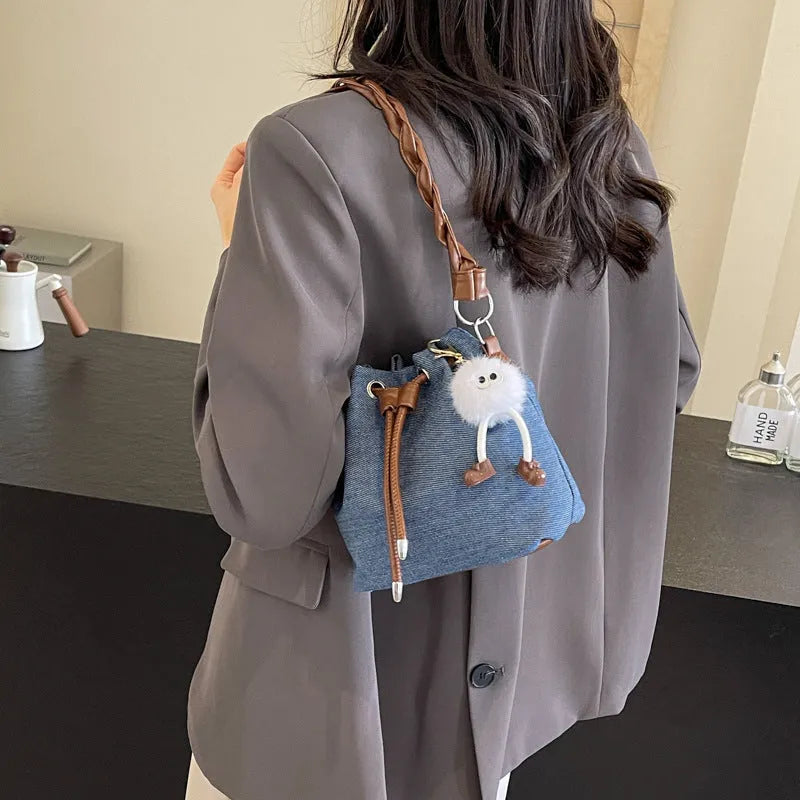 Blue synthetic leather cross body bucket bag with shoulder strap and organised pocket compartments