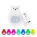 White silicone cartoon bear night light with remote control on a table.