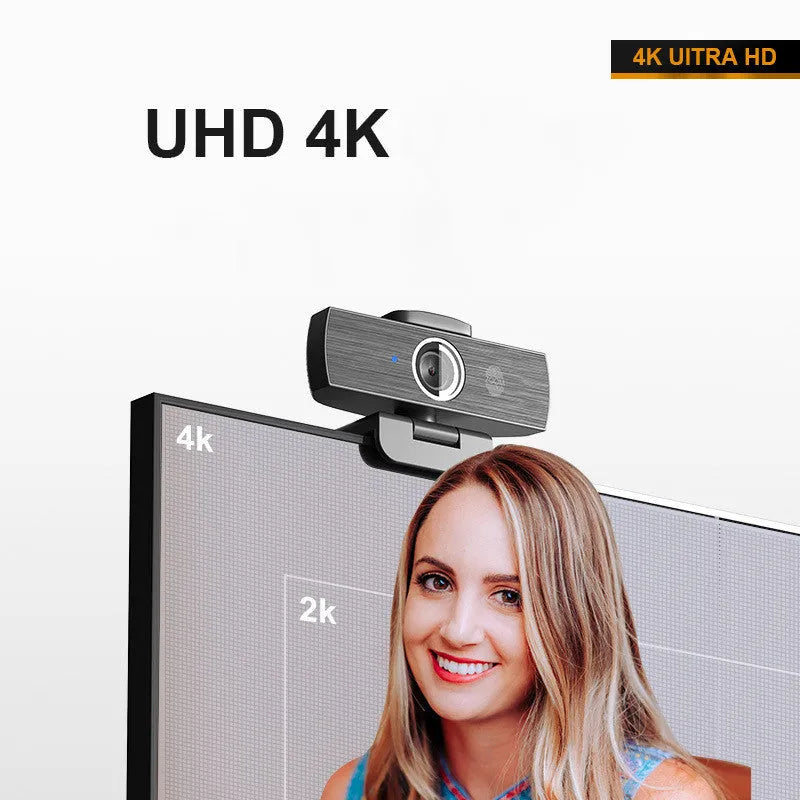 Matte black 4K USB webcam on a desk with a detached magnetic privacy cover and a long cable.