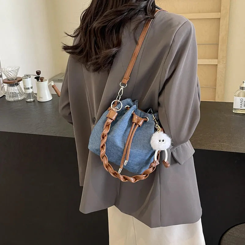 Blue synthetic leather cross body bucket bag with shoulder strap and organised pocket compartments