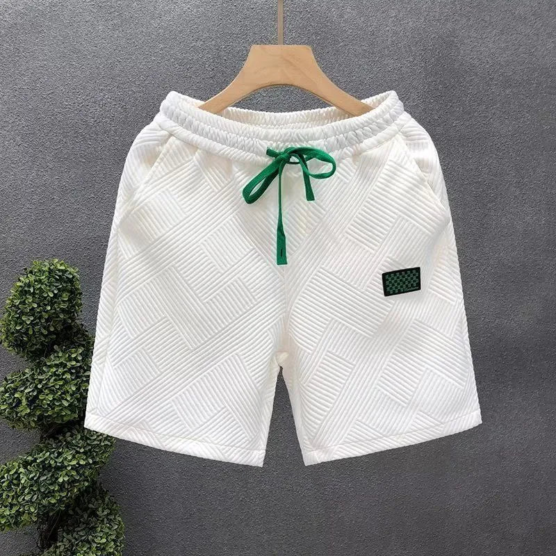 Men's solid colour polyester sports shorts on a hanger, showing elastic waistband and casual cut.