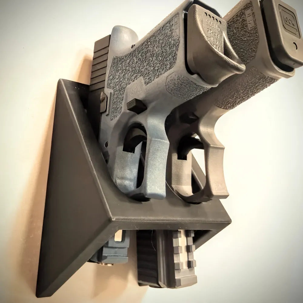 Black punk-style plastic stand for displaying a toy pistol.