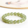 Polished Hetian Jade ball bead bracelet in deep clear water colour on a wrist.