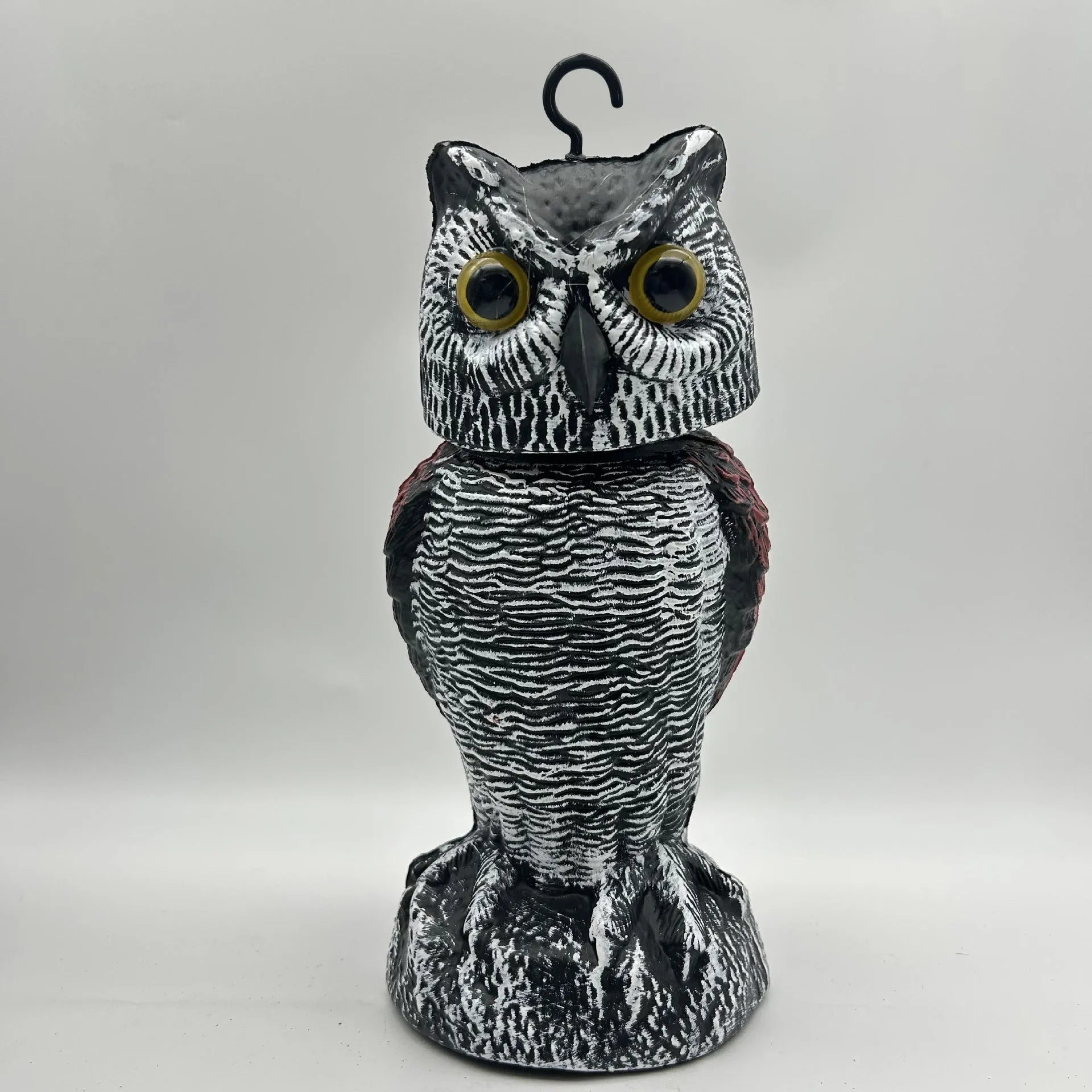 Artificial owl bird deterrent ornament with moving head in outdoor setting
