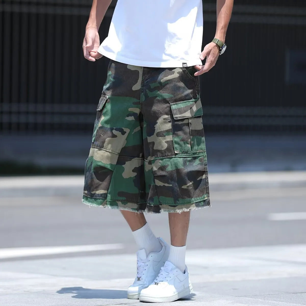 Man modelling loose-fit camouflage shorts in a retro workwear style for summer.