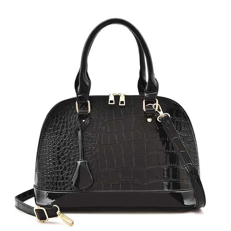 Large shiny black PU leather crossbody shoulder bag showing shell-shaped structure.