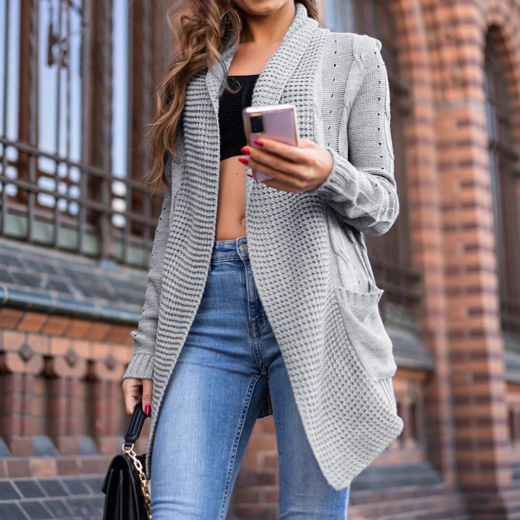 Grey loose-fit women's cardigan coat with pockets, shown in a street fashion style.