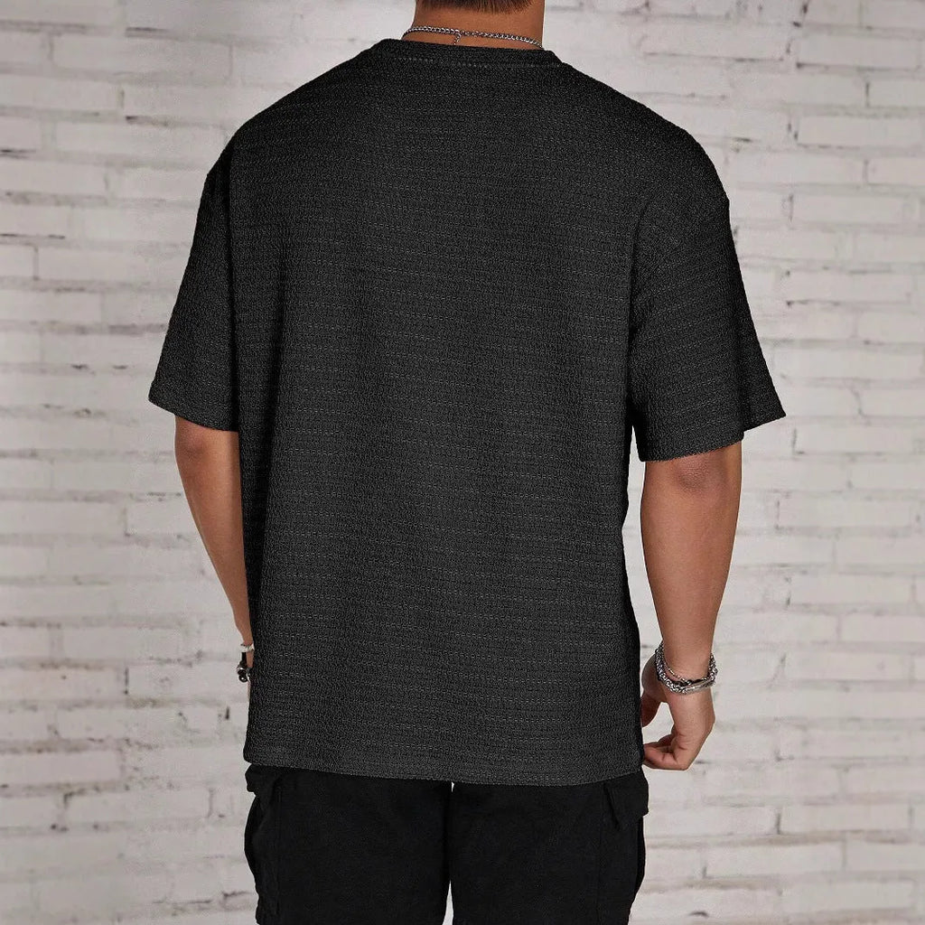 Men's slim fit loose hollow polyester t-shirt in black, shown on a model.