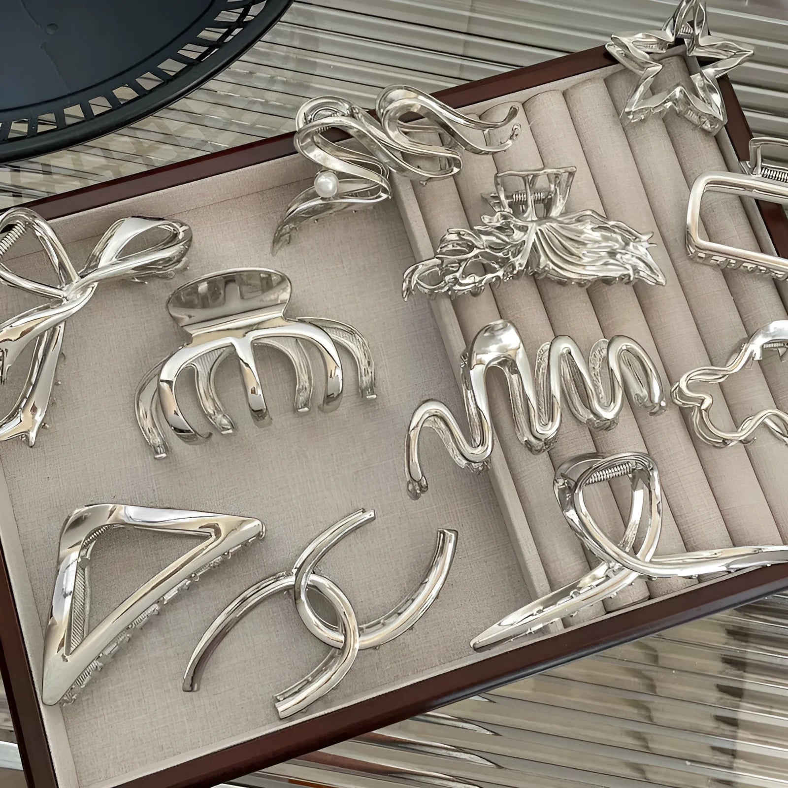 Silver metal hair claw barrettes collection showing multiple designs including wave, rose, and bow shapes
