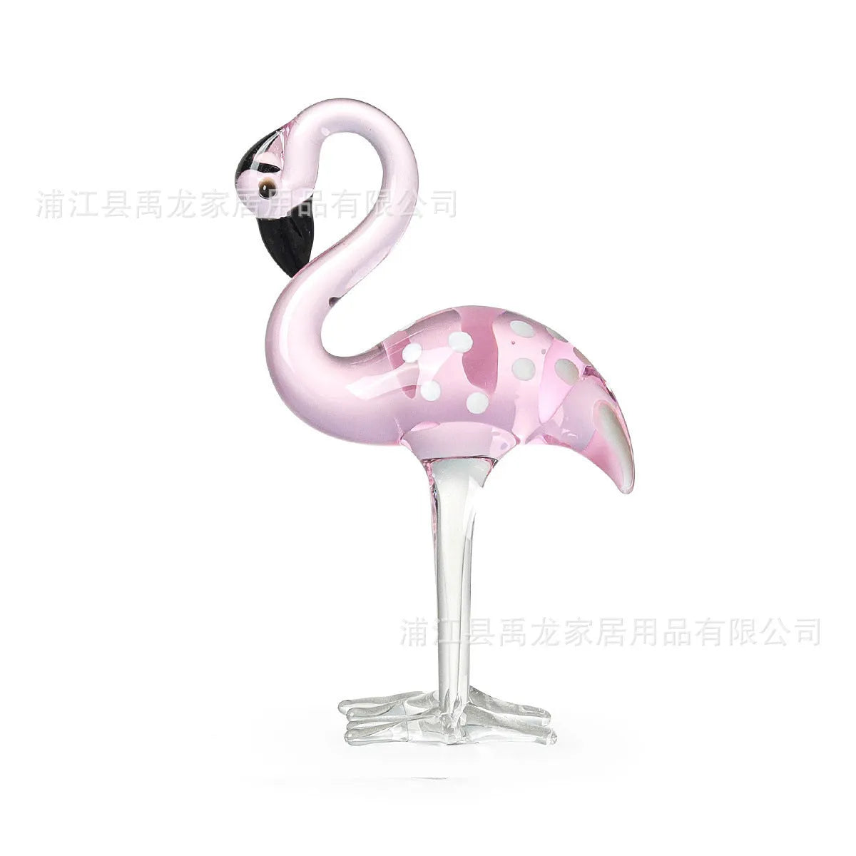 Clear crystal flamingo decorative sculpture with pink dots on a table.