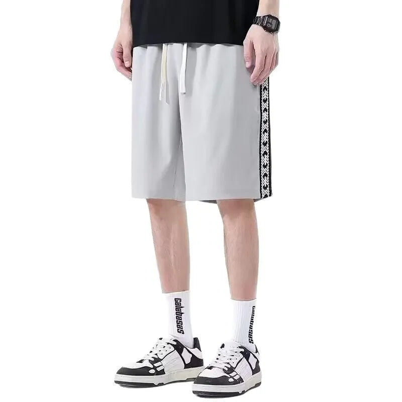 Man wearing loose-fit black track pants made from polyester with a micro-elastic fabric.