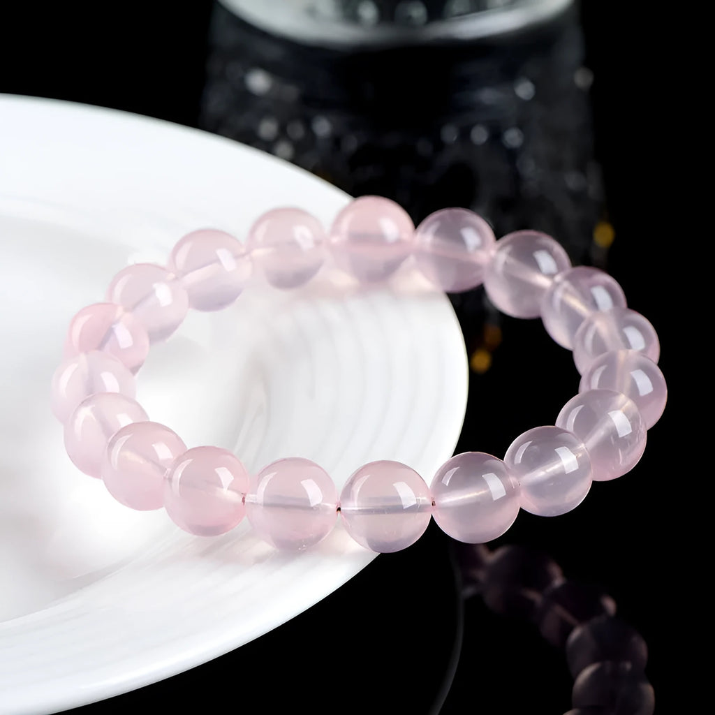 Natural Starlight Crystal round bead bracelet in pink, showing polished finish on wrist.