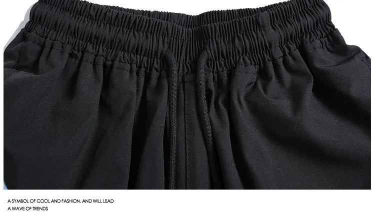 Man wearing black loose-fitting quick-dry training shorts with an elastic waist, suitable for sports and casual wear.