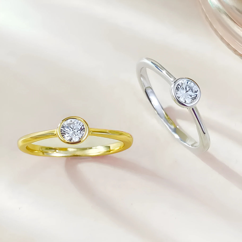 Minimalist silver women's ring with a crown shape and linear detailing in gold or platinum colour.