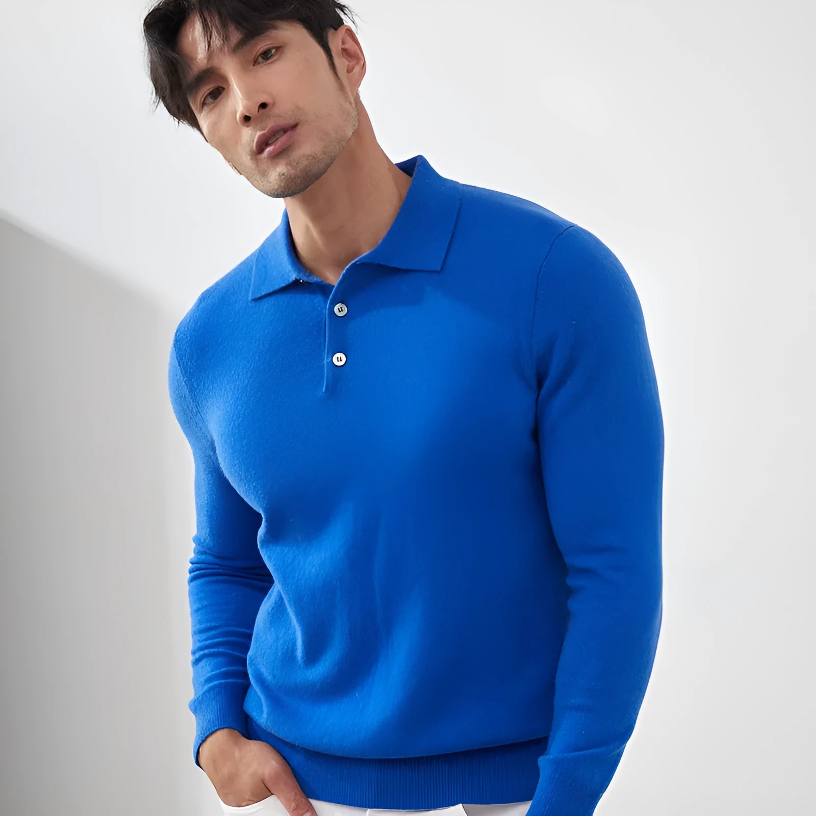Man wearing a sapphire blue cashmere pullover sweater with a polo collar in a loose fit.