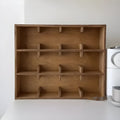Square solid wood storage rack with multiple grid compartments for cups in a birch wood finish.
