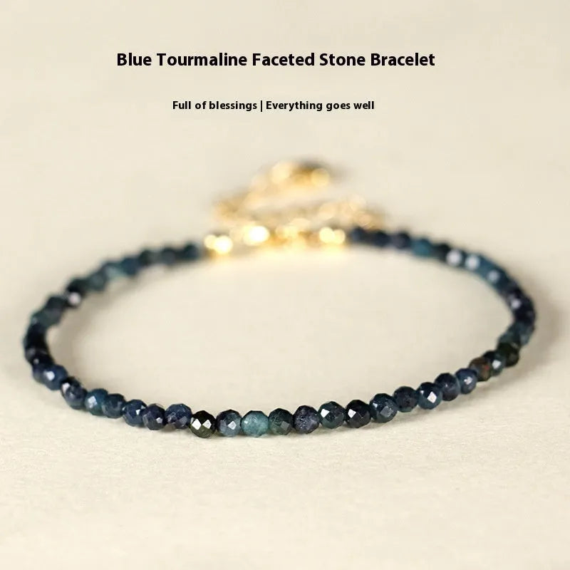 Blue tourmaline bracelet with 3mm cut beads and spacer design on white background