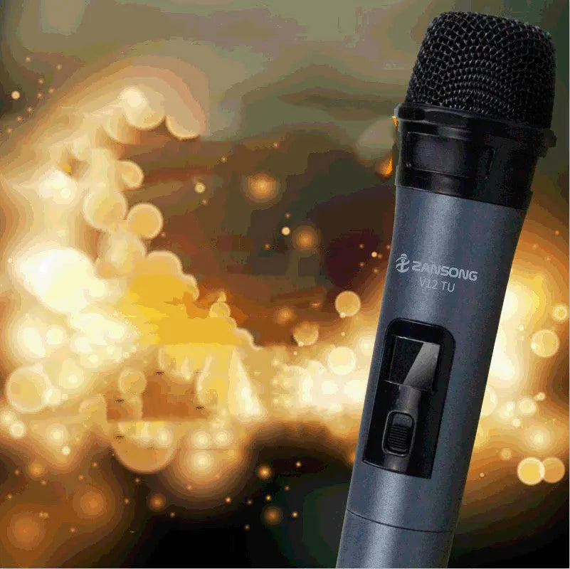 Black ZANSONG V12 dynamic wireless microphone with USB receiver and cables on a table.