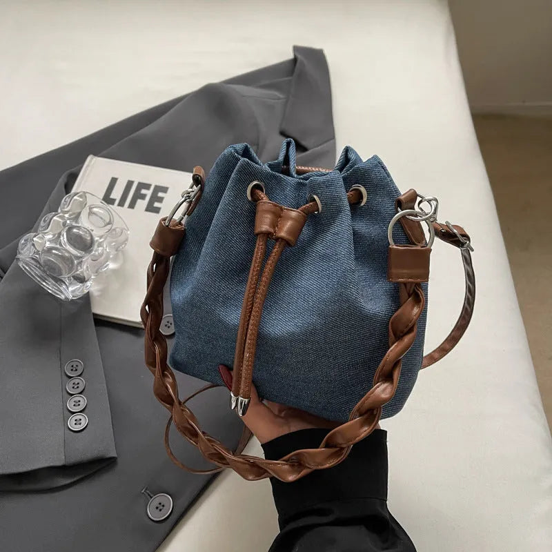 Blue synthetic leather cross body bucket bag with shoulder strap and organised pocket compartments