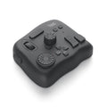TourBox NEO black creative controller for video editing on a desk next to a tablet.