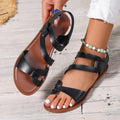 Women's flat sandals with Velcro strap, round toe, and rubber sole shown in black colour.